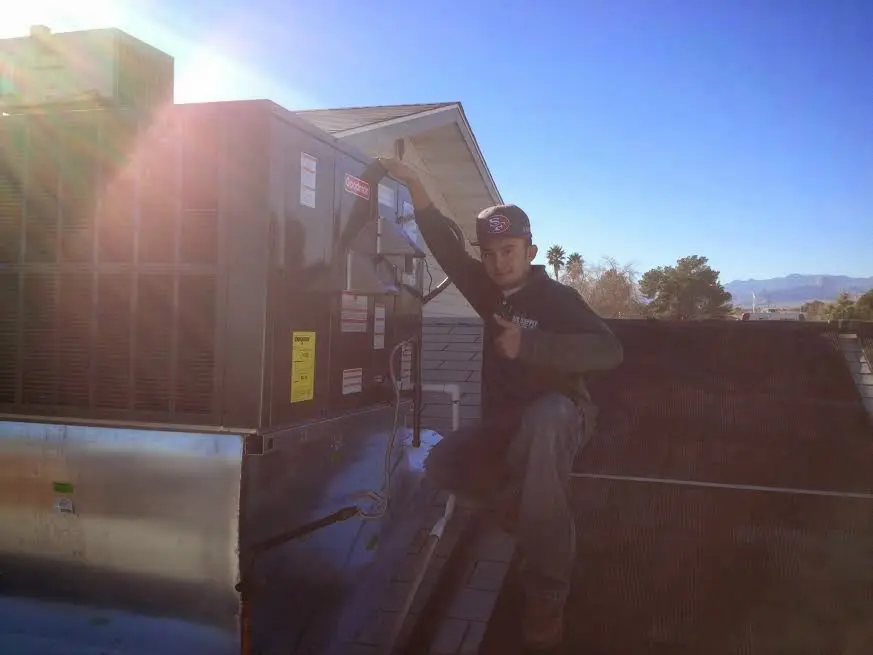 HVAC technician performing Air Duct Repair on a rooftop unit in State College